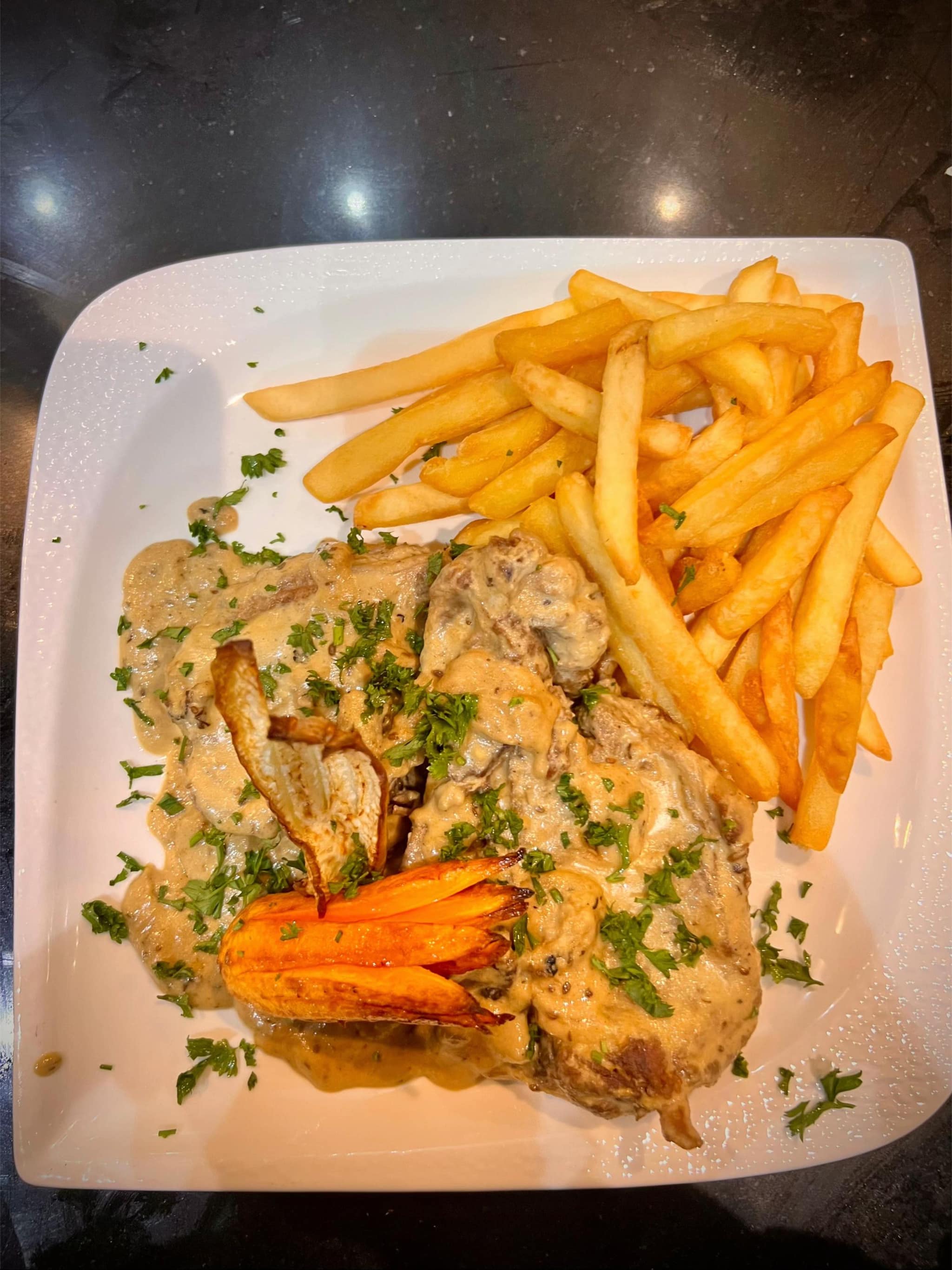 Assiette — viande en sauce crémeuse aux champignons, frites et carottes rôties